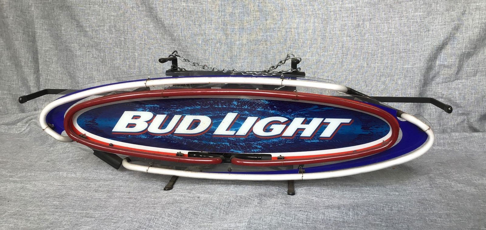 Bud Light Neon Sign: Bud Light red and blue neon sign 26.5"w x 5.5"d x 8.5"h. **Please Note: This item is NOT eligible for in-house shipping. Please refer to the terms and conditions of this auction for recommended shippe