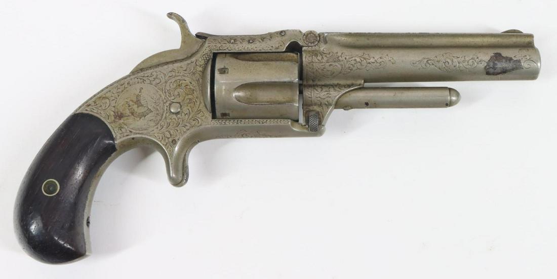 Early Engraved Smith & Wesson No 1 1/2 New Model Second Issue: 32 Rimfire, 3 1/2" bbl, SN 34787. Gray patina over 95% nickel finish shows small areas of flaking on right side of muzzle, good bore, engraved frame and barrel marked on top of barrel rib in one line