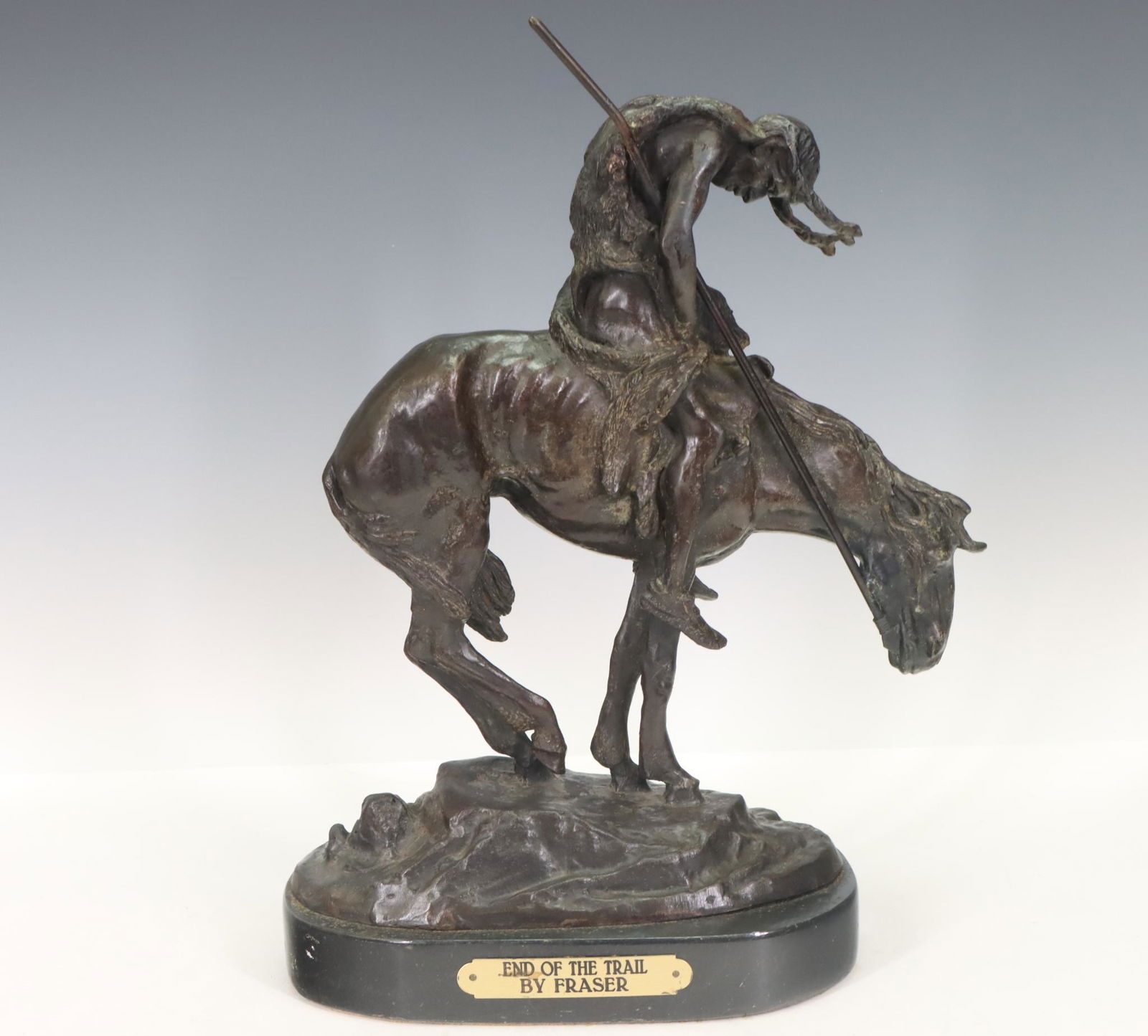 After James Earle Fraser (1876-1953): Bronze sculpture titled "End of the Trail", depicting a Native American man and his horse, signed, mounted to a plinth with brass nameplate. 14.75”h x 11”w x 5.25”d **Please Note: Th