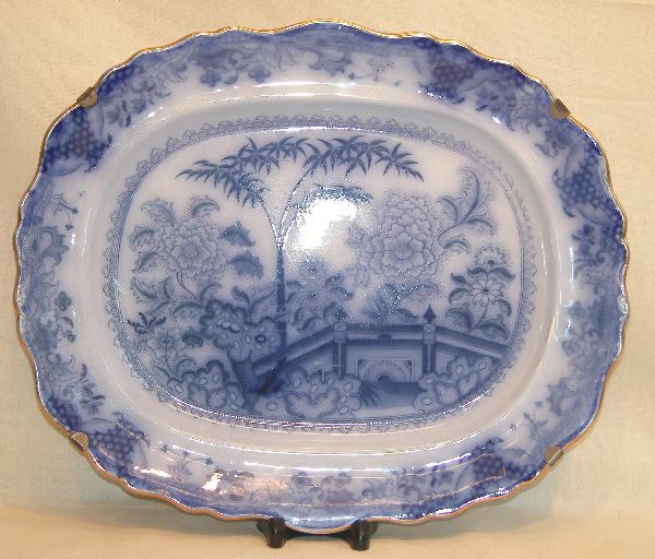 Flow Blue Platter.: Staffordshire platter with flow blue Chinoiserie decoration, gilt shaped rim, marked on the underside for "Davenport Stone China", mark used 1805 to 1820, 17 1/2"l., 15"w. Condition: wear to gilding,