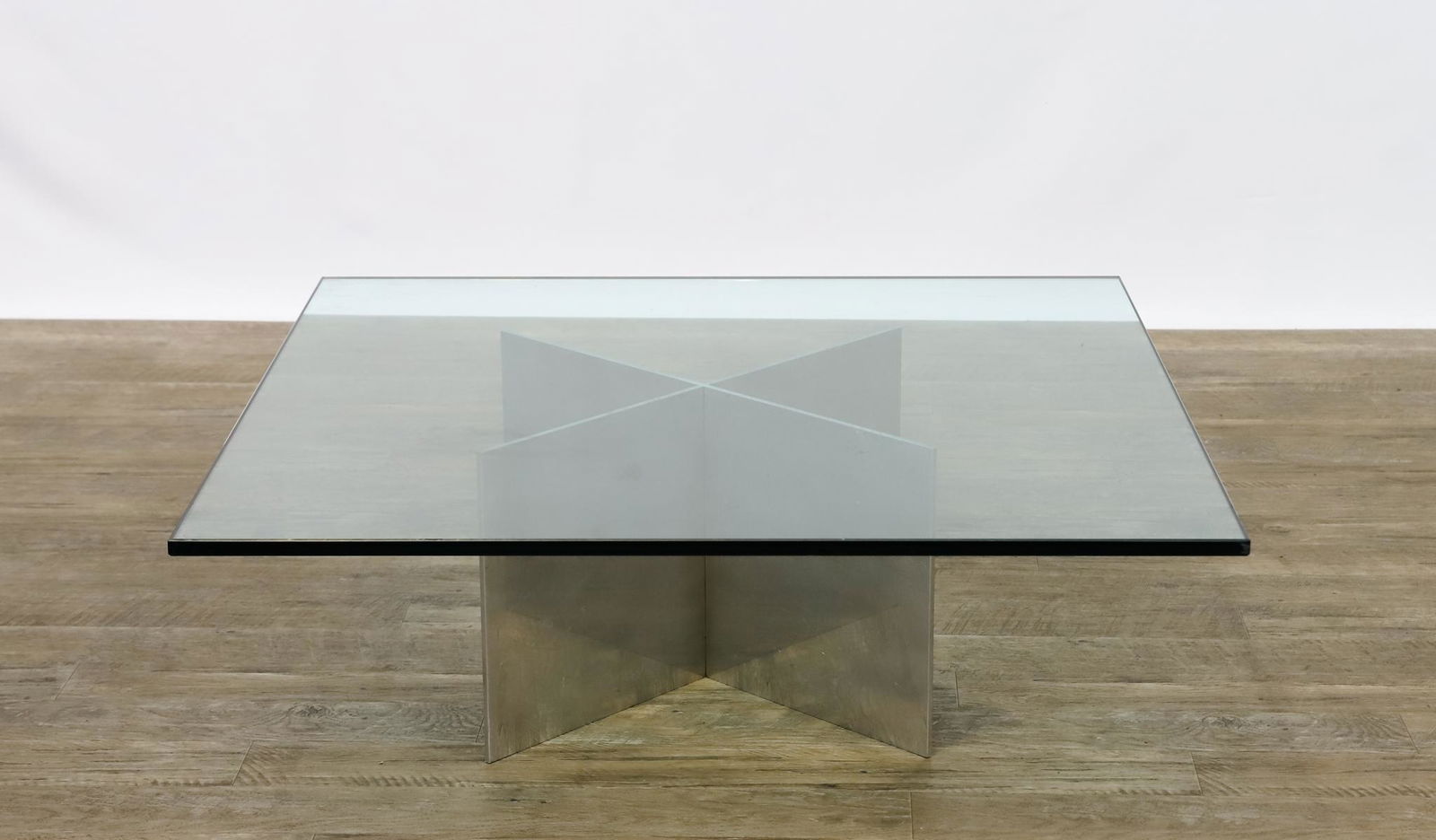 Paul Mayen for Habitat Coffee Table: Polished aluminum X-form base in two parts, with thick square beveled glass top, unmarked. 12.5"h x 35.5"w x 35.5"d **Please Note: This item is NOT eligible for in-house shipping. Please refer to the