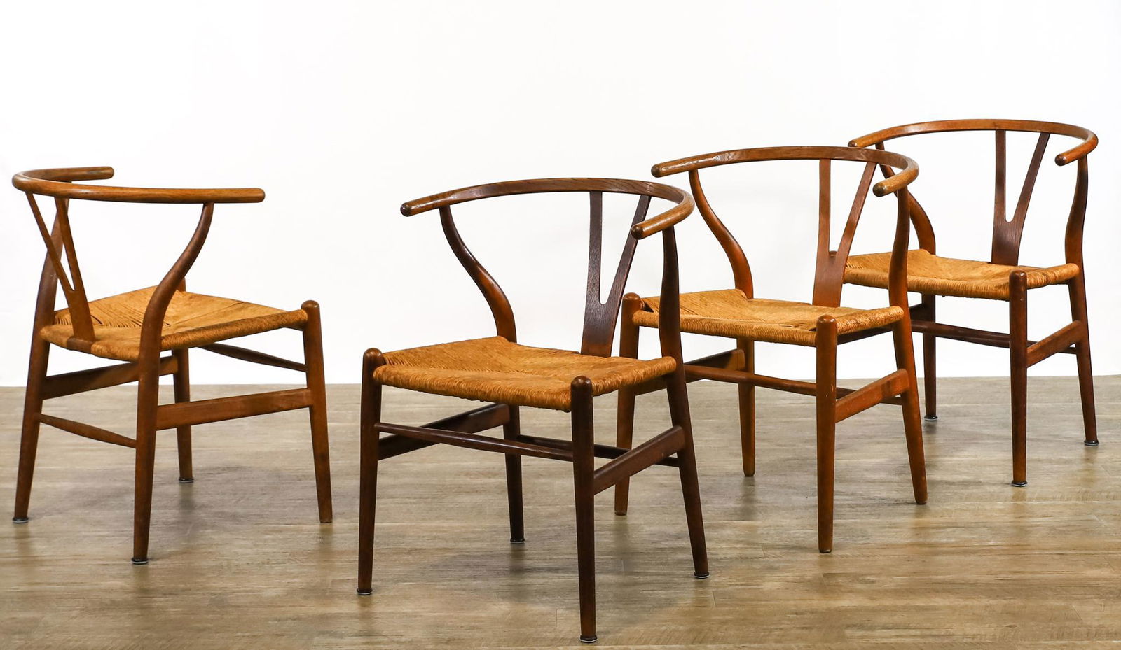 Hans Wegner for Johannes Hansen Wishbone Chairs: CH24 "Wishbone" chairs, teak with steam bent top and supports, Y-shaped back, round tapered legs, and woven paper cord seats. Set of (4), some labeled. 29"h x 19"w x 19"d, seat height 16.5" **Please N