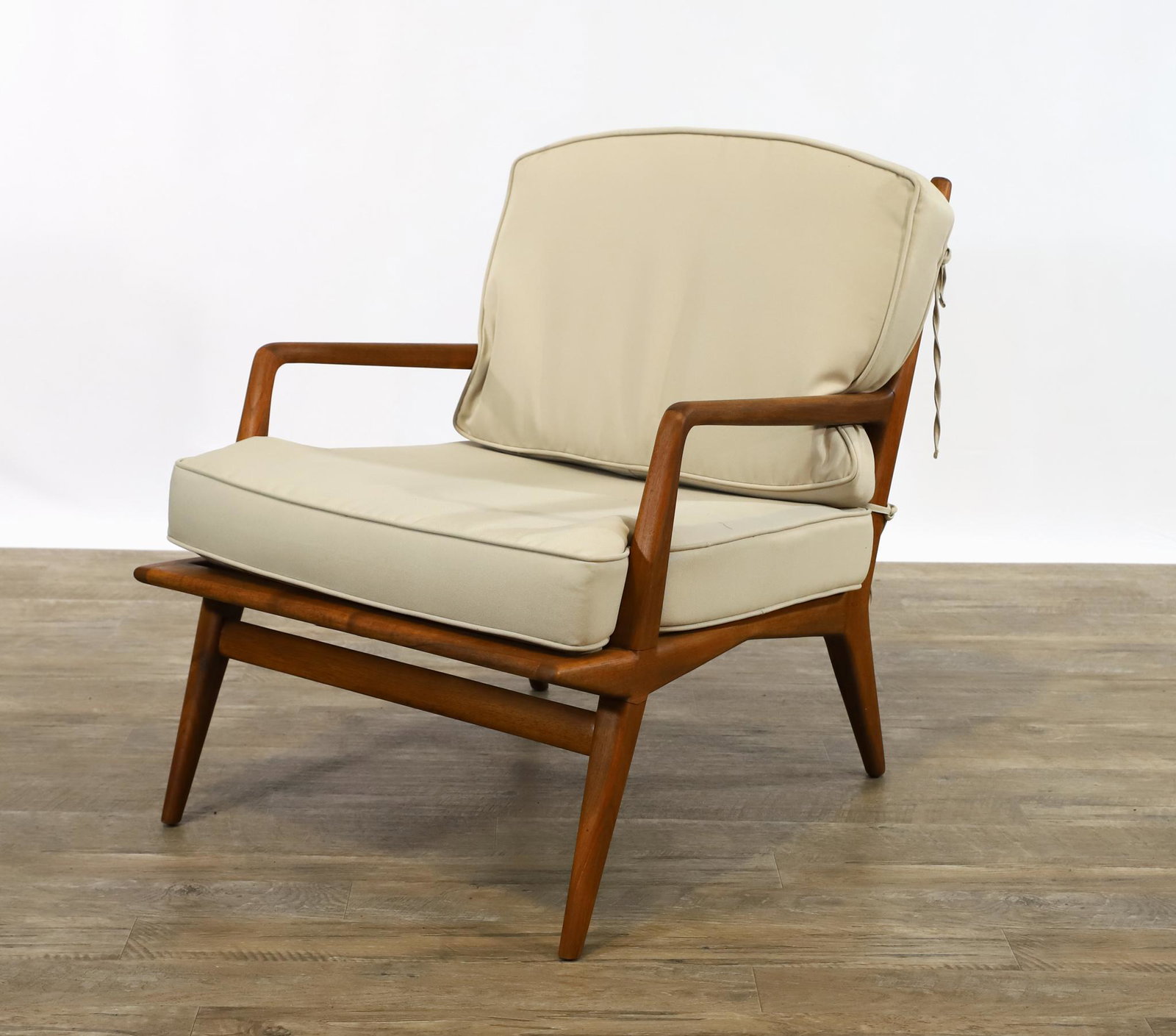 Carlo de Carli for Singer and Sons Lounge Chair: Walnut armchair with splayed tapered legs, beige seat and back cushions, labeled. 28"h x 24"w x 27"d, seat height 17" **Please Note: This item is NOT eligible for in-house shipping. Please refer to th