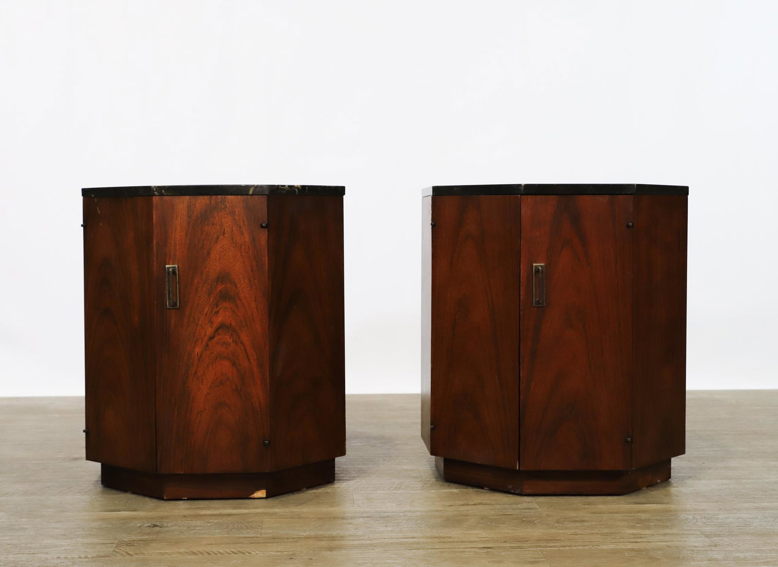 Octagonal End Tables: Manner of Harvey Probber, pair of walnut veneer end tables with stacked marble tops, each with cabinets with a shelf, and bronze finished pulls. Some chips and scratches to the top; other wear. 22"h x
