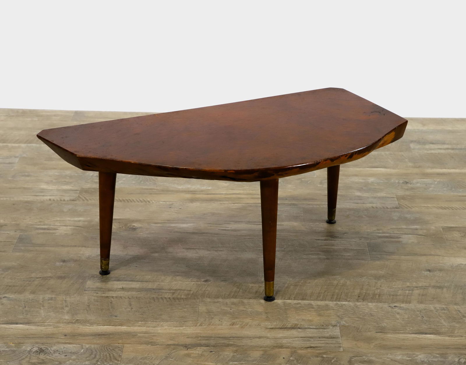 Live Edge Occasional Table: Burlwood top on round tapered legs with brass sabots. Surface wear. 14.5"h x 33"w x 16.25"d **Please Note: This item is NOT eligible for in-house shipping. Please refer to the terms and conditions of