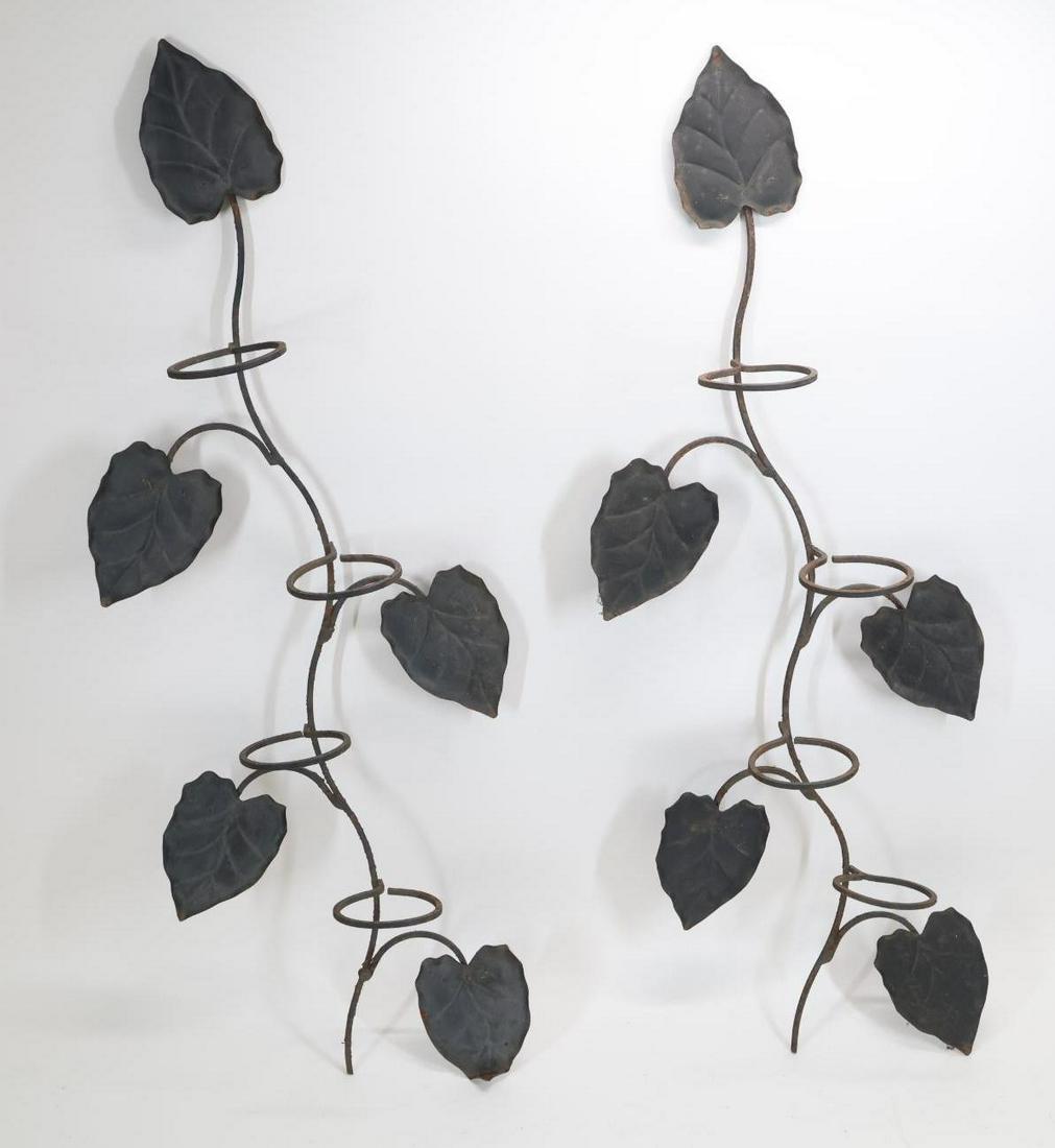 Manner of John Salterini Hanging Planters: Wrought iron pair of hanging planters in the form of espaliered trees, unmarked. Some rusting; the lowest leaf of one planter has a bend and the support needs some re-soldering. 45”h x 17"w x 6.