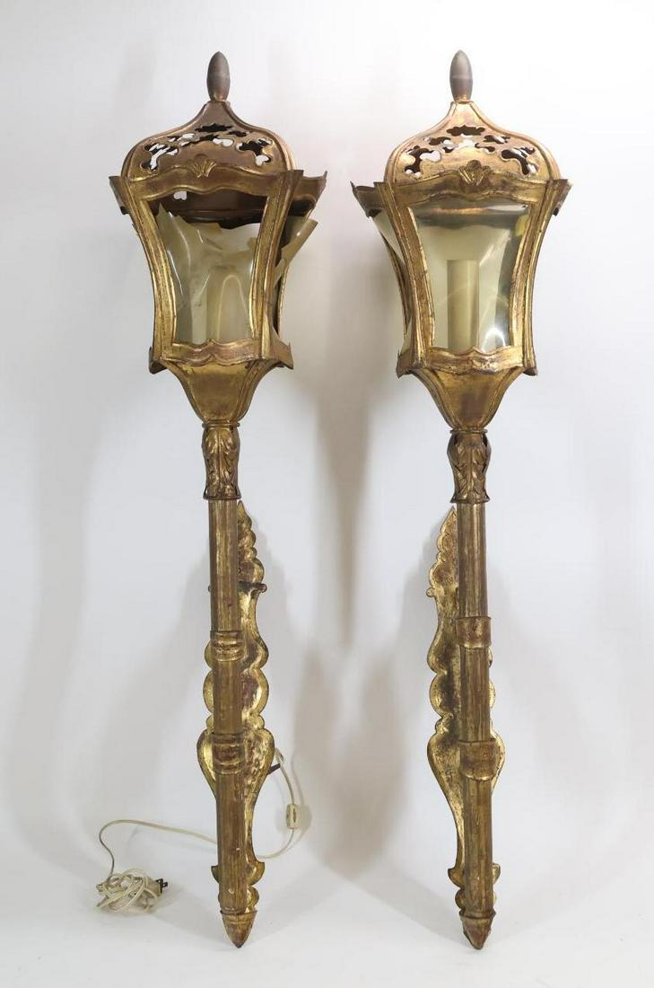 Italian Tole Torch Sconces: Gilded and painted torch form pair of sconces, electrified, with pierced tops, acanthus accents, and fiberglass windows. Marked "Made in Italy". Some loss to the windows. Both need rewiring. 43”
