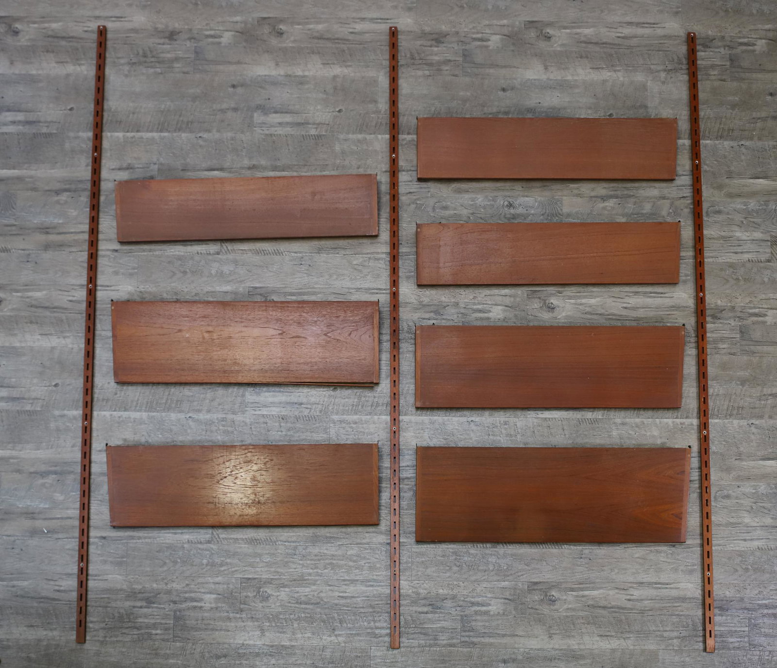 Kai Kristiansen for Feldballes Mobelfabrik Shelving System: Danish modern wall unit in teak, with 78.75"h hanging rails (3), 7.25"d shelves (3), 9.5"d shelves (3), and 11"d shelf (1); all shelves are 3.75"w. The shelves are labeled. Assembly required; no screw