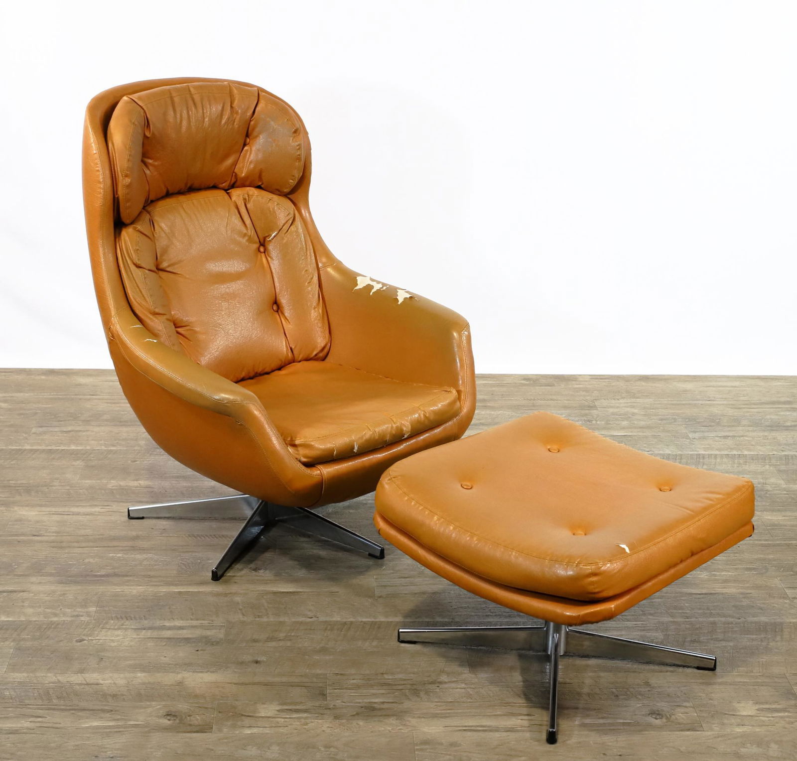 Selig Imperial Egg Chair and Ottoman: Swedish swivel and tilt lounge chair and ottoman with tan tufted vinyl upholstery and chrome bases. Labeled "Made in Sweden", with Doerner Faultless mechanism. Tears and other wear to the upholstery.