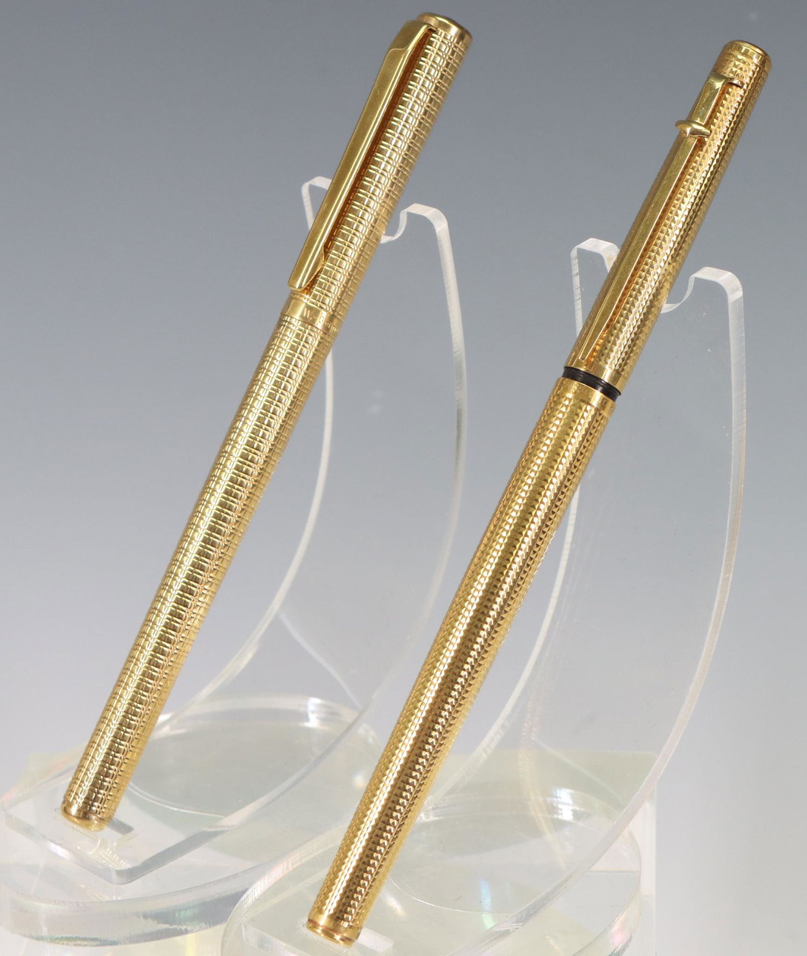 Caran D'Ache & Elysee Fountain Pens, 14K Nibs: Caran D'Ache Fountain Pen, gold textured finish, 14k L Nib, has been inked. Elysee Fountain Pen, gold-plated finish, 14k M Nib.