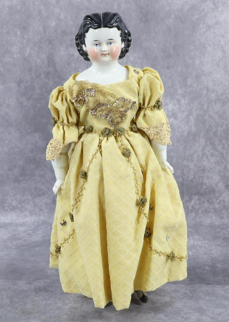 CHINA DOLL(S).: 17" Unmarked 1870's-1880's doll with deep shoulder plate, black hair, blue eyes, pink cheeks. Cloth body, chubby china lower arms, legs with painted gray boots and green tassels. Dressed in vintage dr