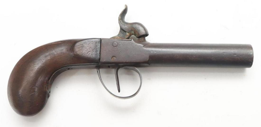 Center Hammer Percussion Pistol: .55, 3" bbl, NSN. Dark brown patina, fair bore, unique 1 piece barrel/receiver with strong center hammer lock holds on half and full cock, wood bag style grip shows average handing. Good condition. An
