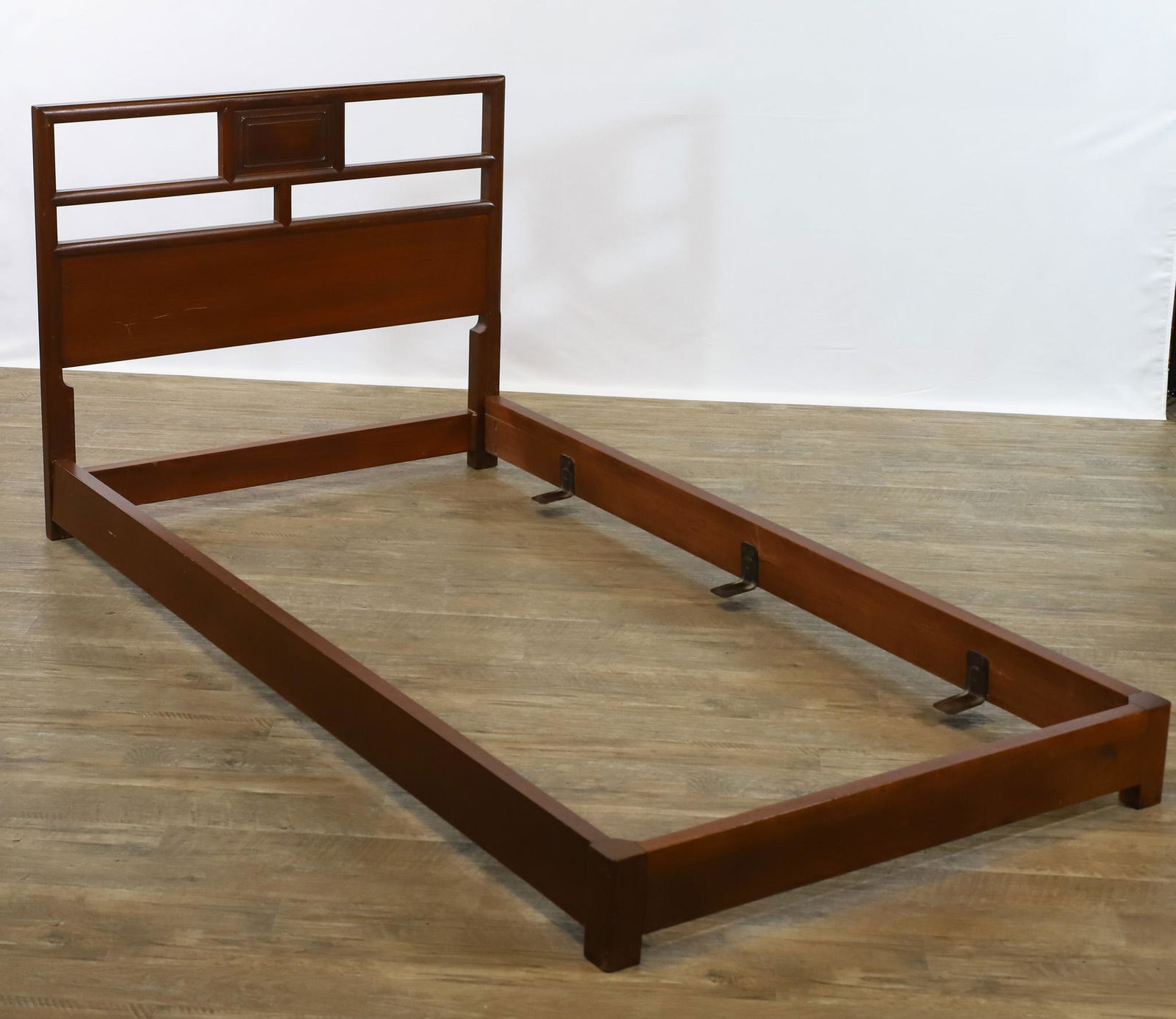 Michael Taylor for Baker Far East Beds: Mahogany chinoiserie pair of twin beds. Includes casters, currently detached. Scattered surface wear including scratches, dings, and some loose veneer. Each 35"h x 79"l x 42"w overall, 76"l x 39"w mat