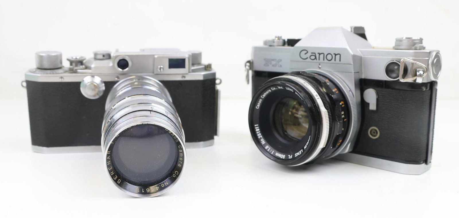 Canon Cameras: Canon camera, No. 57336, with Canon Serenar f:4, 135mm lens. Canon FX camera with Canon FL 1:1.8, 50mm lens, No. 261911.