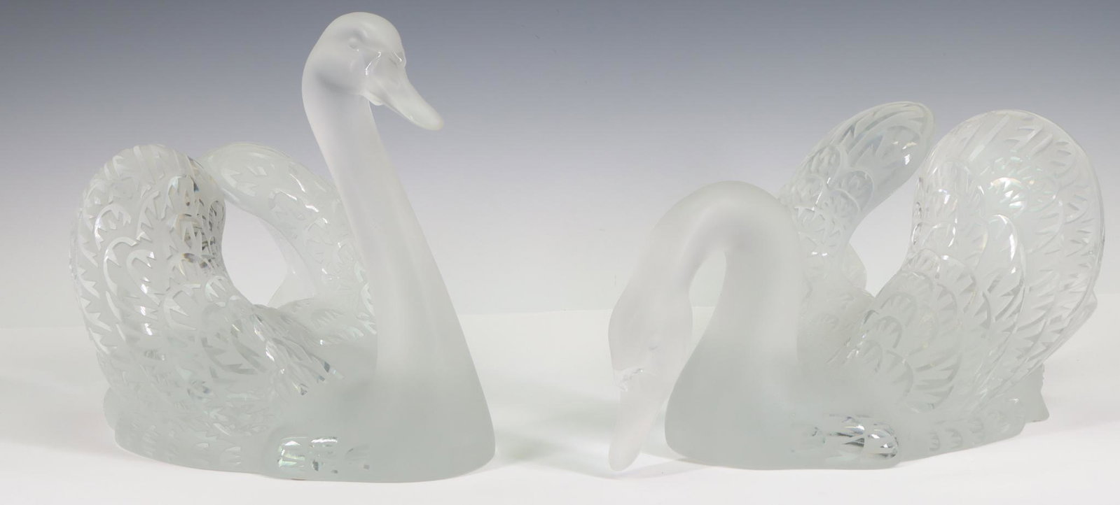 Lalique Glass Swans: French art glass swans, "Cygne (Tete Droite)" and "Cygne (Tete Penchee)", frosted and clear, each signed at the base. 9.5"h x 7 "w x 12.5"d, and 7"h x 8.5"w x 14"d