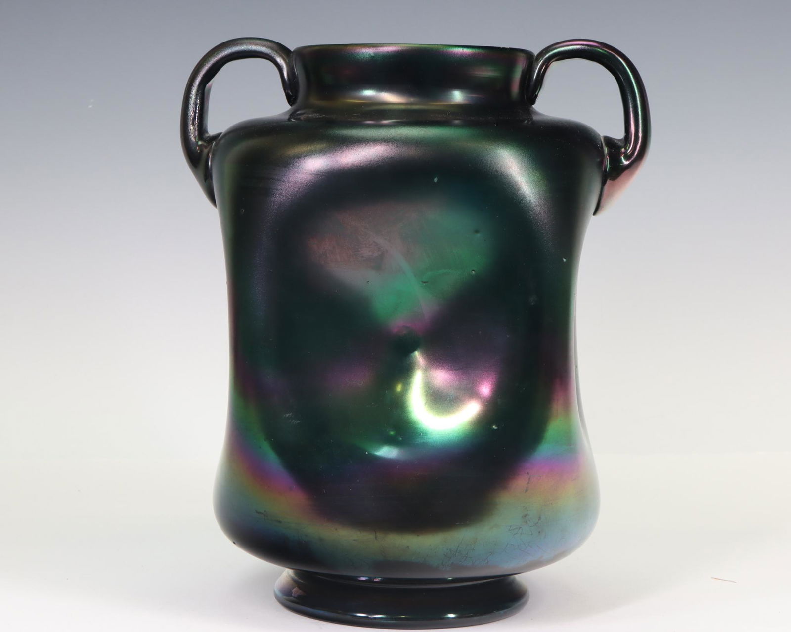 Thomas Webb Green Bronze Glass Vase: Iridescent glass, "Green Bronze", with concave sides and handles, late 19th century, unsigned. 9"h x 7.5"w x 6.5"d