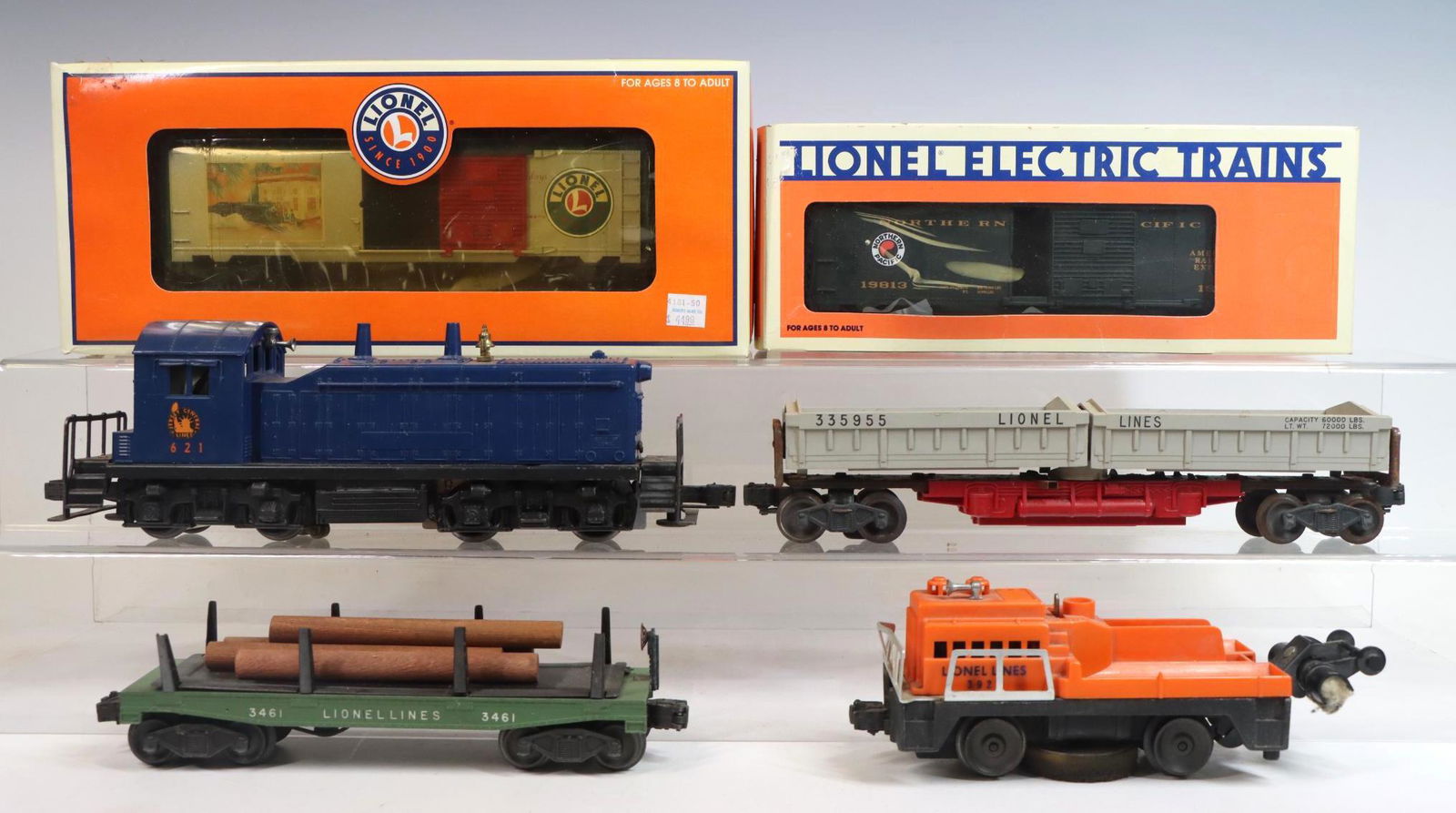 Lionel Diesel Engine and Train Cars: O gauge, 3-rail Jersey Central switcher diesel #621, track cleaning car #3927, log car, Northern Pacific boxcar, Christmas boxcar and twin bin dump car.