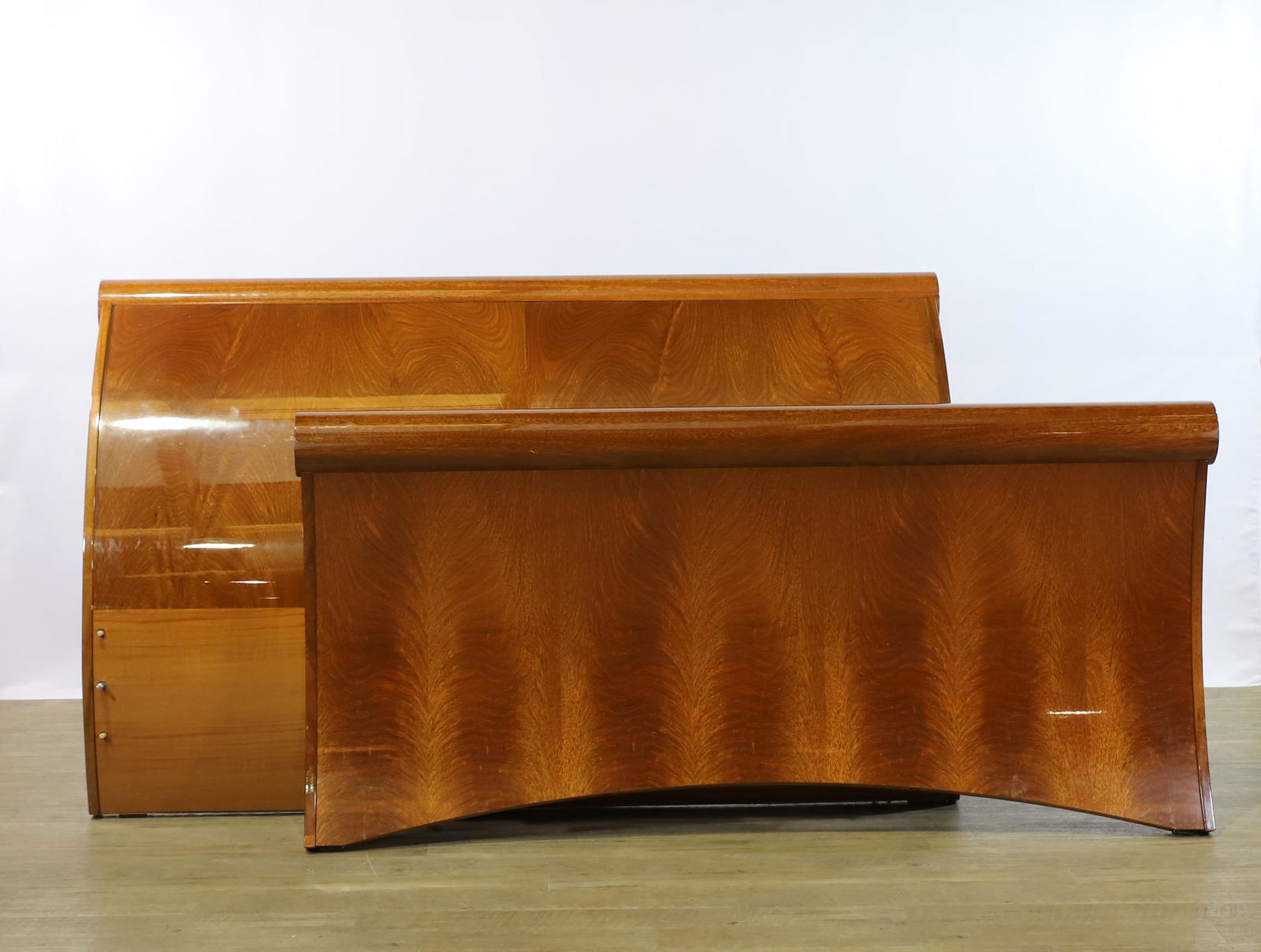 Italian Flame Mahogany Sleigh Bed: Outswept headboard and footboard and two side panels in lacquered flame and burl mahogany veneer in varying grains. Includes (6) mattress support beams and hardware. Missing a dowel. Headboard 41.5"h