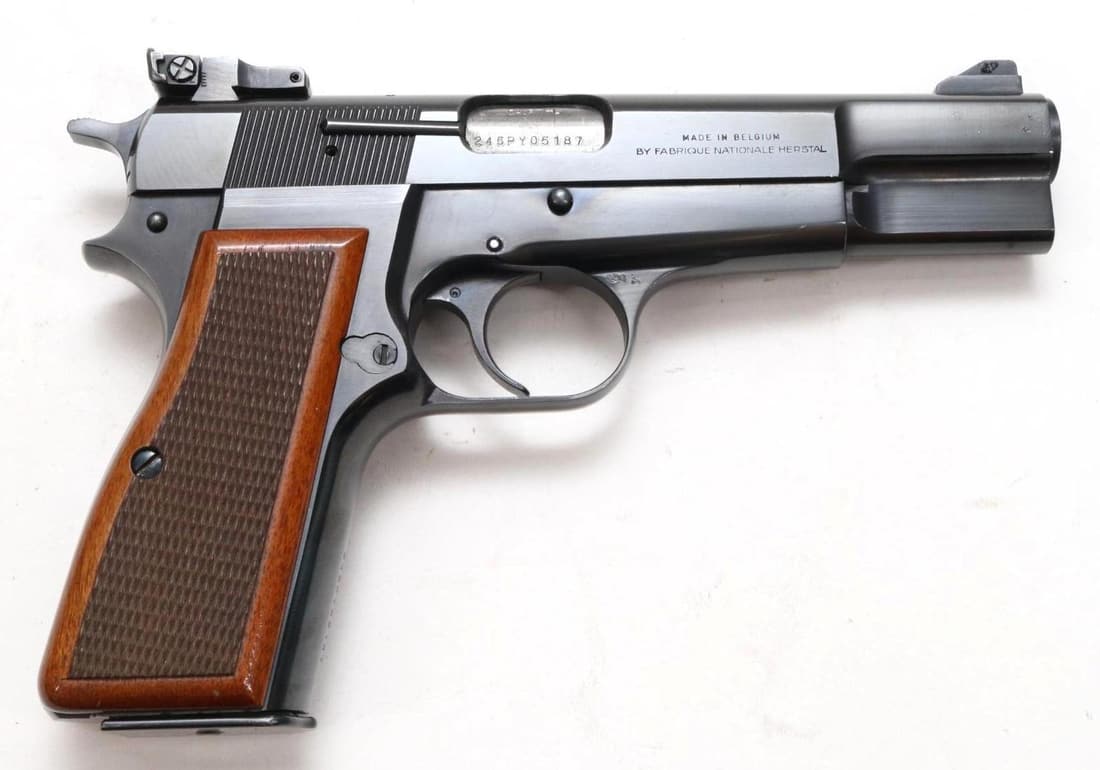 FN/Browning Hi Power Semi Automatic Pistol: 9mm, 4 5/8" bbl, SN 245PY05187. 98% blue finish shows a few small scratches and small area of abrasion on right side of slide at muzzle, good bore, adjustable rear sight, checkered wood grips show ave