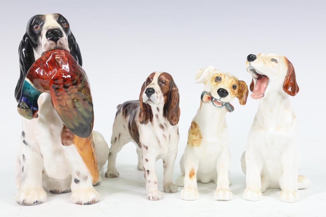 Royal Doulton Figurines (4): Porcelain dog figures including Springer Spaniels (2), one with a bird in his mouth and 2 Jack Russell Terriers, one yawning and the other with a bone. All marked on bottom. Largest 5.25"h