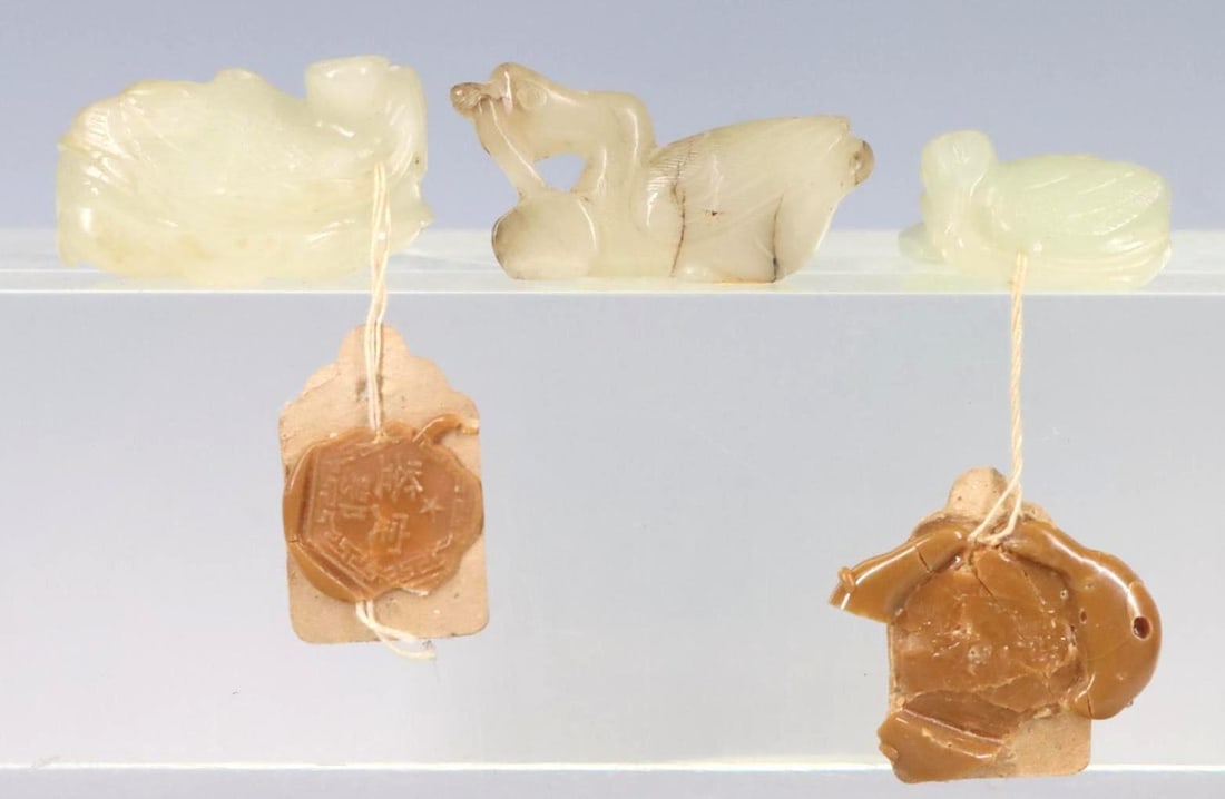 Chinese Jade Toggles: Pale celadon carved jade toggles , figural and animal form, two with Jianding wax seals. Largest 1.5”w