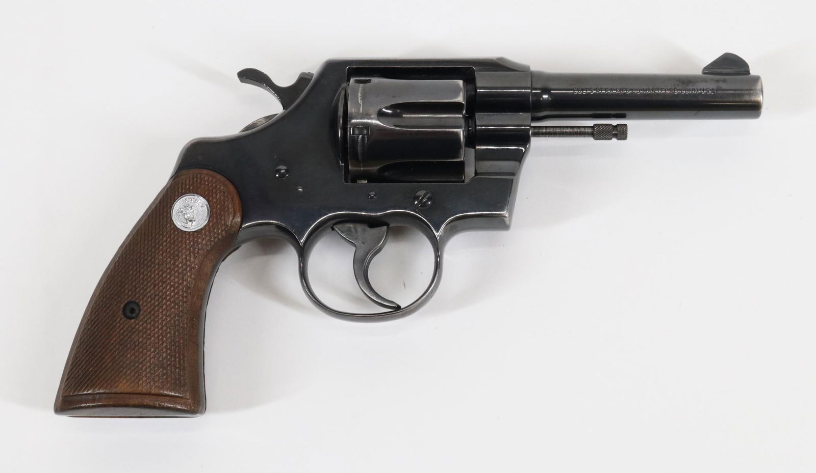 Colt Official Police Double Action Revolver: 38 Special, 4" bbl, SN 854257. 90% blue finish shows thinning and loss (appears to be holster wear) on most edges, good bore, ribbed hammer and trigger, checkered wood grips show average handling with