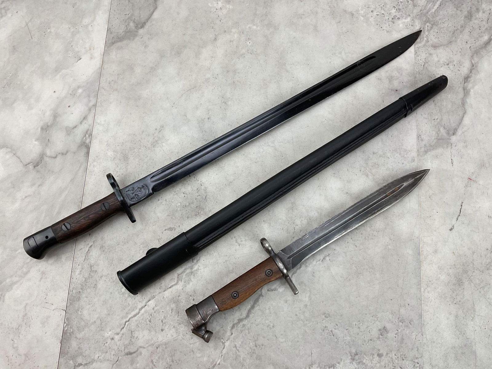 Bayonets (2): 1- British P-1907 Enfield, 17" blade with fullers marked with crown over GR P-1907 ENFIELD on 1 side of ricasso and broad arrow (acceptance mark) crossed swords (bend test) and 3 crown proofs on rever