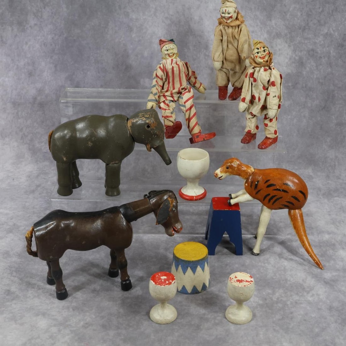 SCHOENHUT.: LOT of Schoenhut Circus figures. (3) Clowns - (2) with a two part head (with ears) and (1) with a solid head. (no ears). Condition: age loss, discoloration. These need to be restrung. (2) Animals with