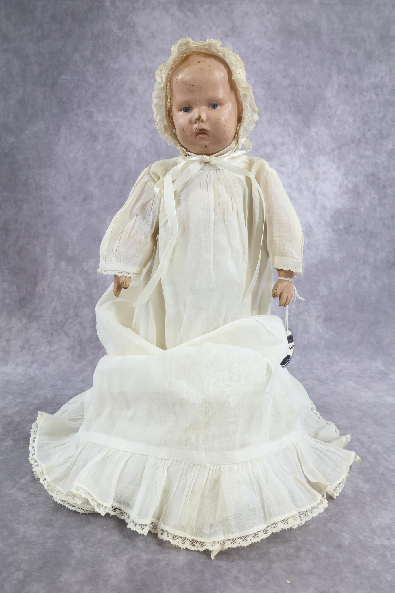 SCHOENHUT.: 14" Model 107 Doll on full jointed body. Impressed marks on back of head and torso. Painted blue eyes, painted blonde hair. No original clothing but dressed in antique white cotton baby gown, bonnet, 