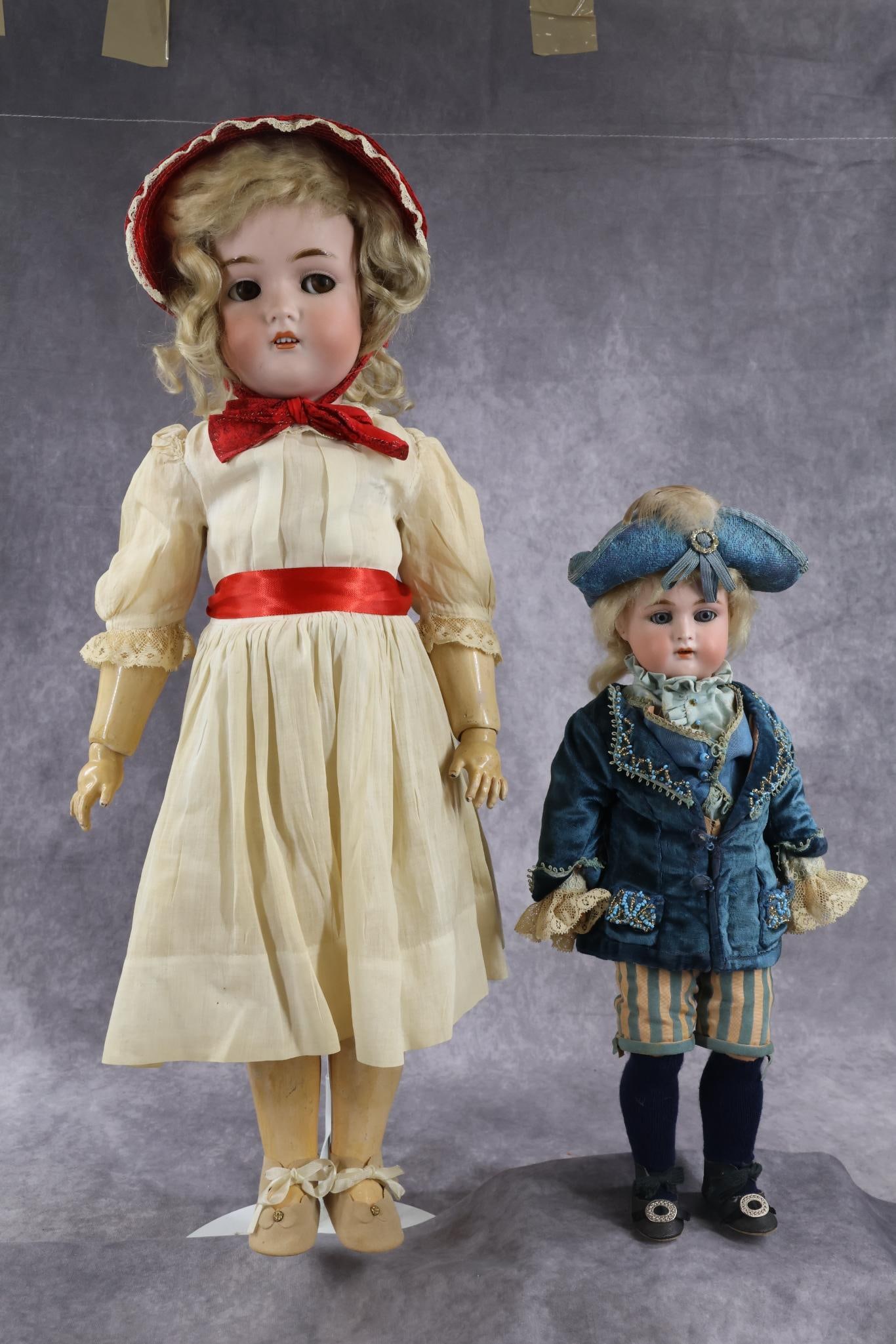 ANTIQUE GERMAN BISQUE HEAD DOLL(S).: Pair of HALBIG K * R Dolls. Both dolls have open mouths, pierced ears, blonde mohair wigs and papier mache ball jointed bodies. 16" "39" Doll with blue sleep eyes. Dressed as a boy in a formal outfit
