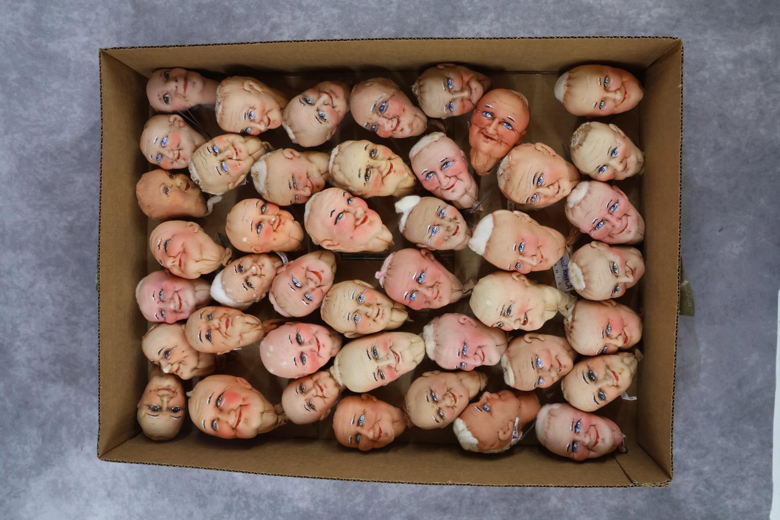 CLOTH DOLL(S)/NOVELTY.: LOT of (42) character HEADS by Bernard RAVCA. 3 1/4" - 4". Both men and women, these are all made of sculpted stockinette with painted features. Many are tagged Made in France. This lot is being sold 