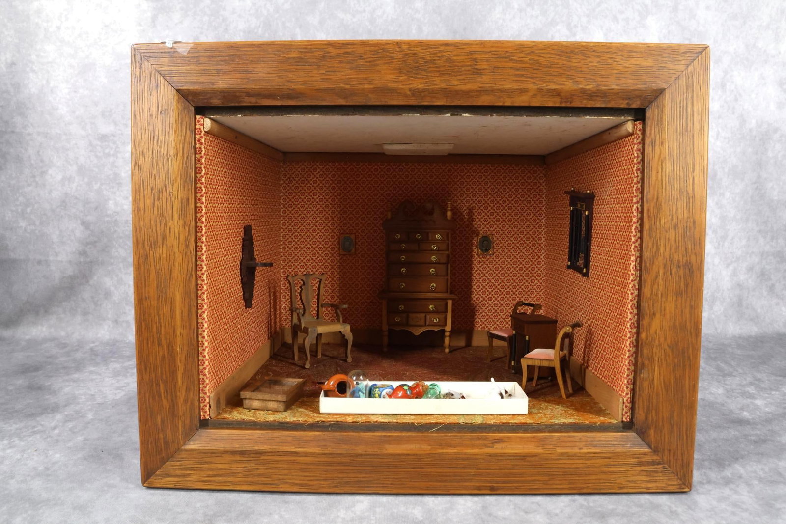 MINIATURES - ROOM BOX.: Room Box. Furniture - Highboy, marked Tynie Toy Chippendale armchair. Pair of side chairs with upholstered seats. Stand. Wall mirror, hanging shelf, hanging shelf. Misc. smalls in glass, china, carved