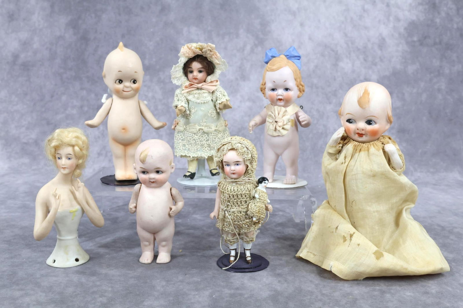 SMALL ALL BISQUE/OTHER DOLLS.: LOT of (7) German and Japanese dolls. German - All bisque: 5" with molded blue bow in hair. Strung arms. 3 3/4" 500 (clover mark) LIMBACH? doll. Strung arms. 3 3/4" Holding china Frozen doll. Strung a