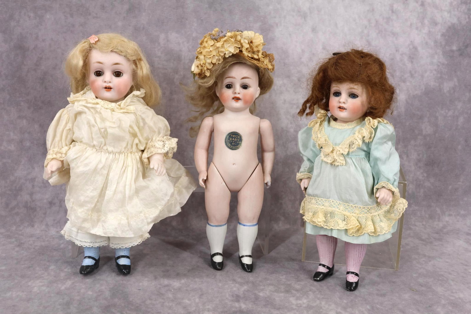 GERMAN ALL BISQUE DOLL(S).: LOT of (3) dolls. All of these dolls have sleep eyes, open mouths, mohair wigs, 5 pc. bodies with painted black heeled shoes, socks. 8 1/2" 208 7 "Prize Baby" doll with brown eyes, blonde wig. White s