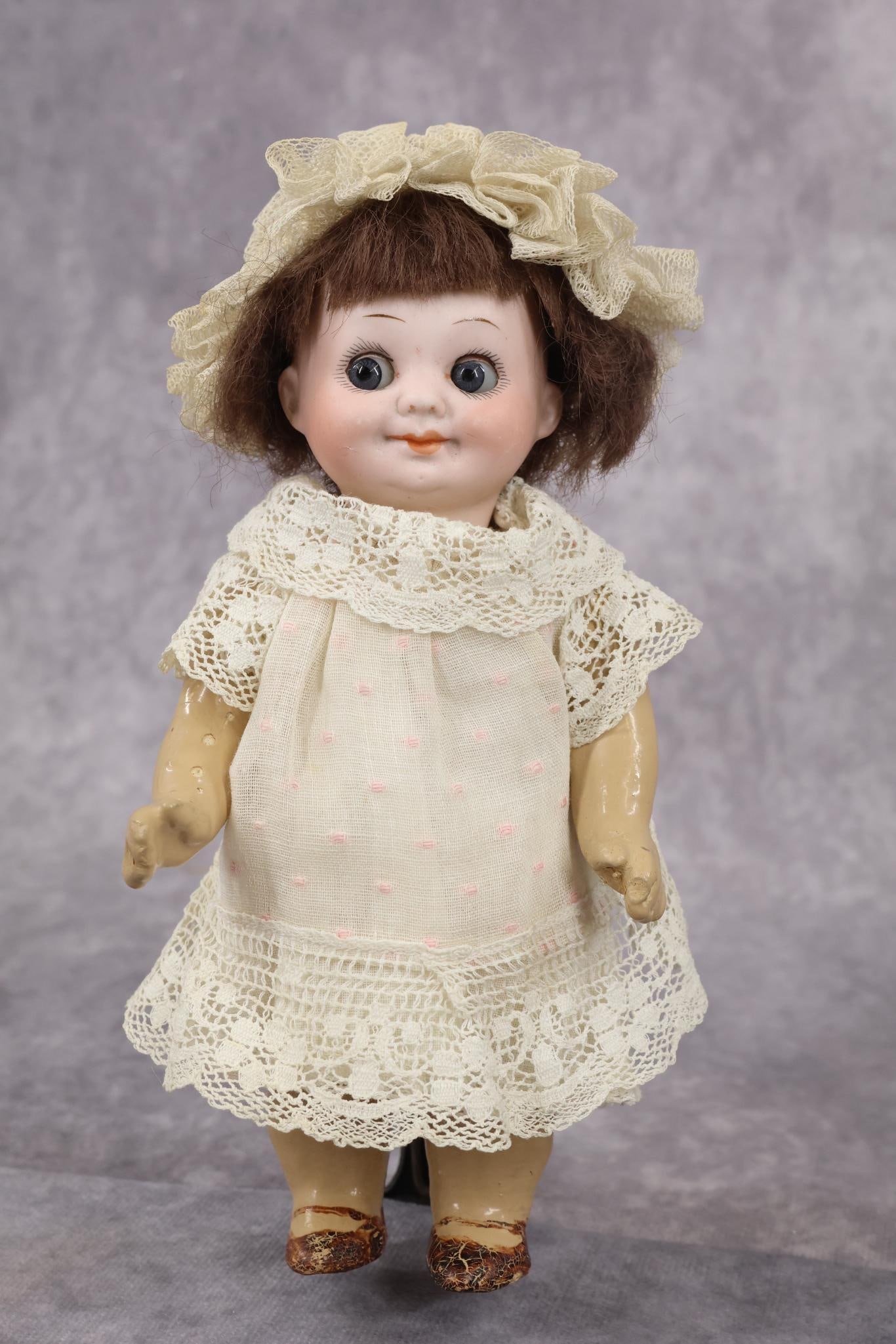 ANTIQUE GOOGLY EYE DOLL.: 7" GERMANY 323A.11/0.M. Doll with blue sleep eyes, closed mouth, brown mohair wig. 5 Pc. papier mache body with painted brown shoes. Dressed in vintage/antique cotton clothing, tulle bonnet. Condition