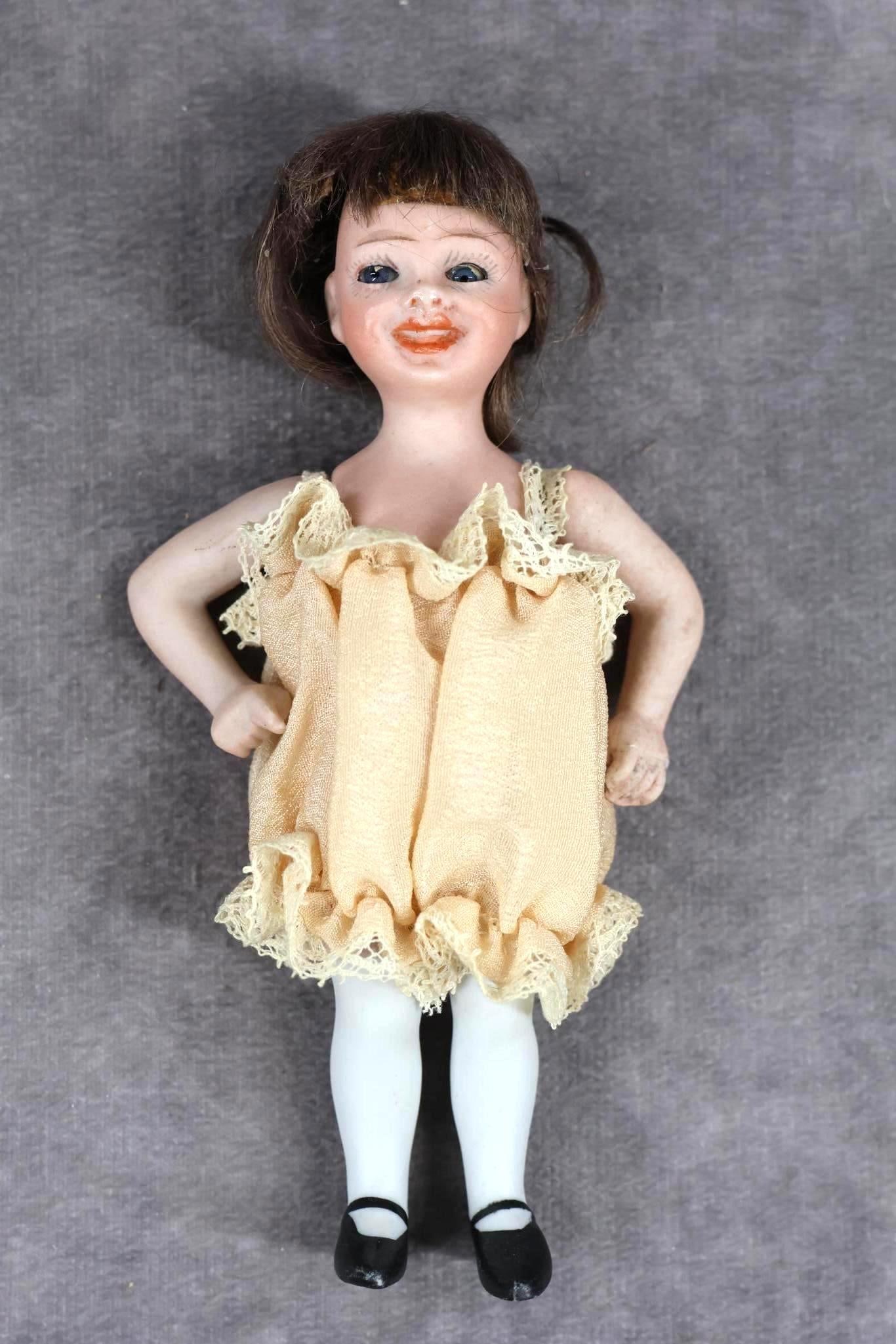 GERMAN ALL BISQUE DOLLS.: ORSINI Character girl with glass eyes. 5" "ViVi" doll. (No paper label on chest.) Marked on back J.J.Orsini (copyright) 1919 47. Stationary blue eyes, brown mohair wig, smiling, open/closed mouth with