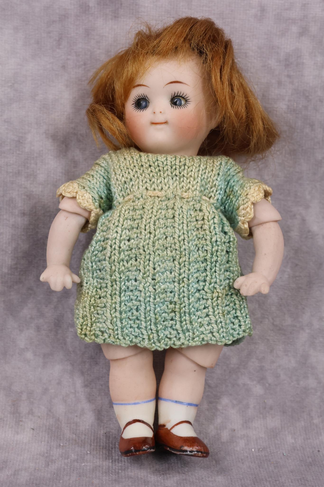 GERMAN ALL BISQUE DOLLS.: 6" 112 2 (KESTNER) Googly eye doll with jointed elbows, knees and swivel neck. Blue sleep eyes, watermelon smile, red mohair wig. Painted brown shoes, white socks. Dressed in vintage 2 pc. aqua croche