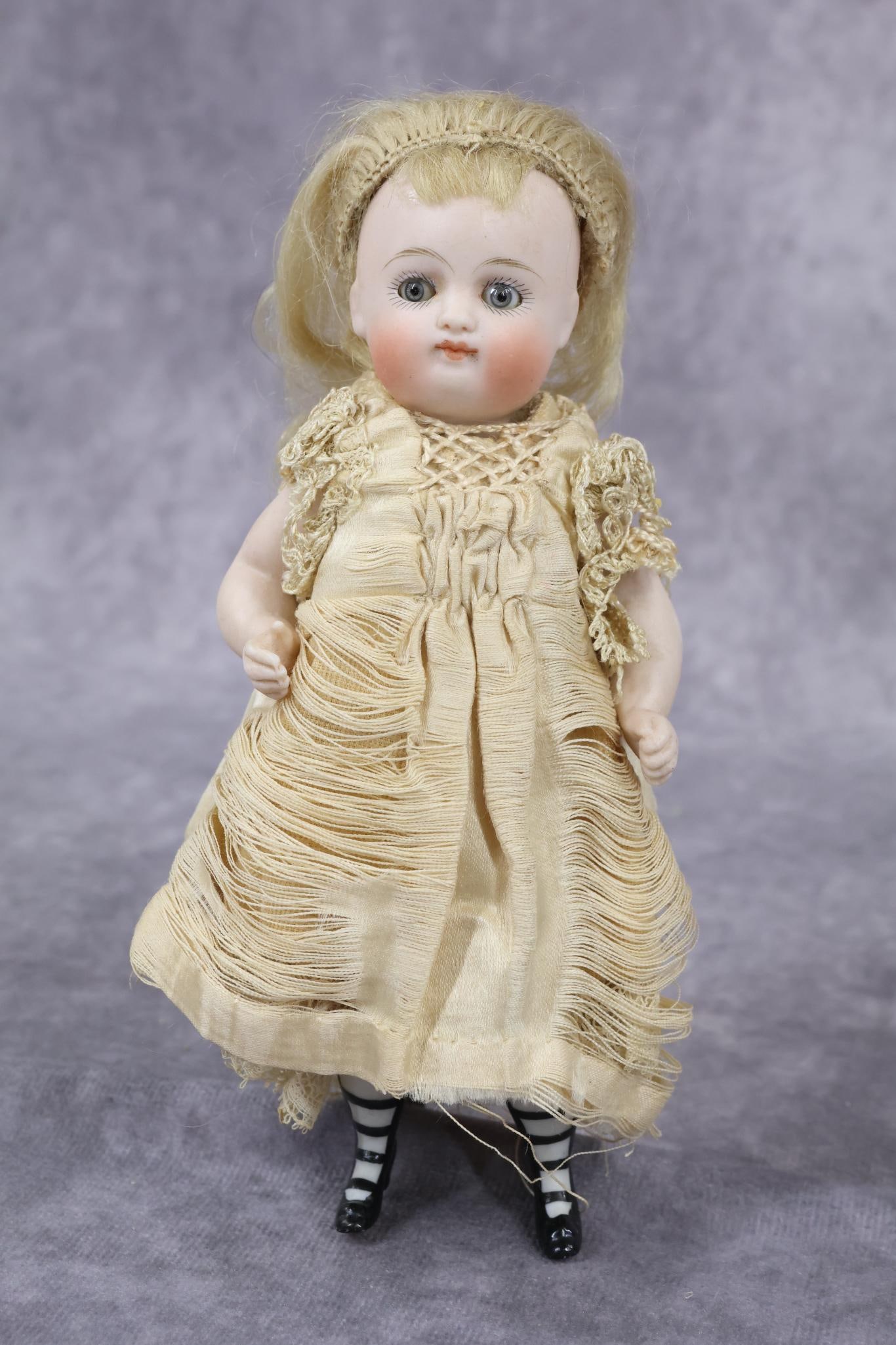 GERMAN ALL BISQUE DOLLS.: 6 1/2" "1" Early pouty type doll (KESTNER) with stationary blue eyes, closed mouth, chubby cheeks, blonde mohair wig. 5 Pc. body with swivel neck. Painted black booties. Dressed in antique clothing - 