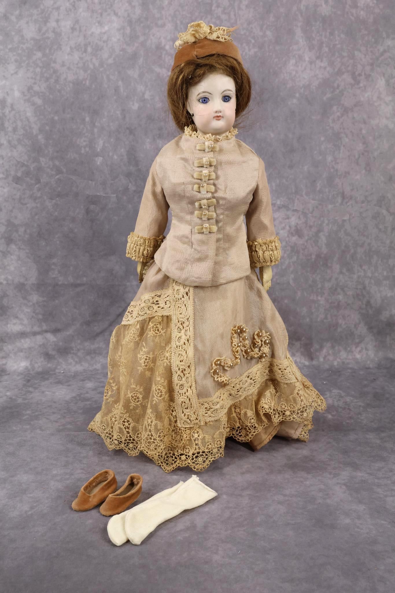 FRENCH BISQUE HEAD DOLL.: 17" F.G. (Scroll mark) Fashion doll. Bisque head on a bisque shoulder plate. NOTE - This doll is either a reproduction or has had the head restored. Stationary blue eyes, pierced ears, brown human hai