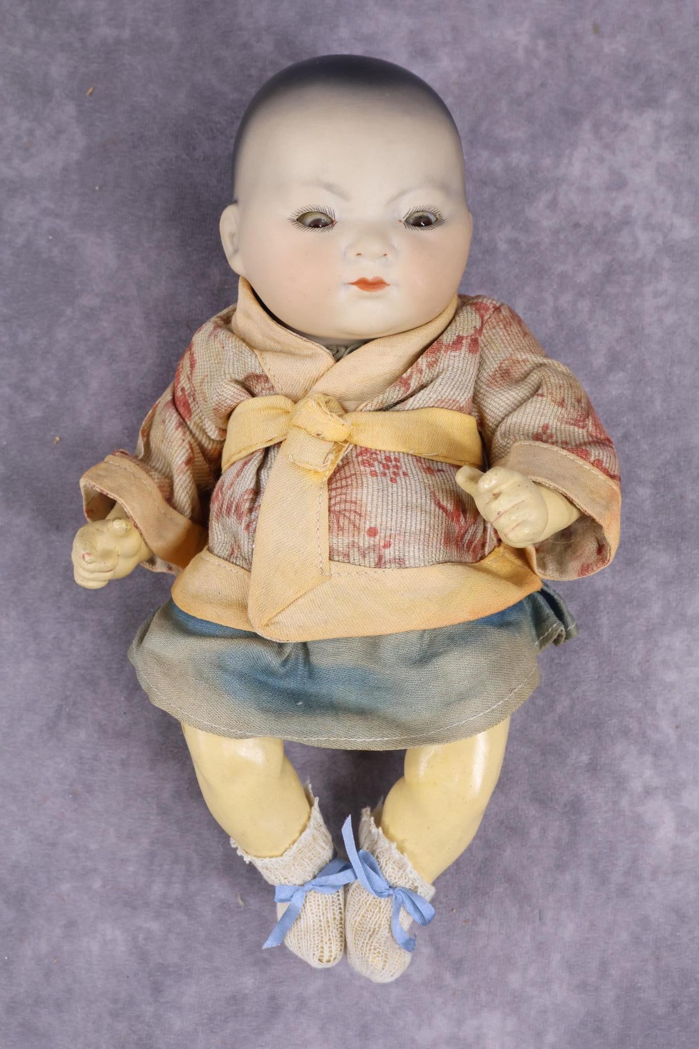 ANTIQUE CHARACTER DOLL, BISQUE HEAD.: 10" A. (Six point star symbol with ELLAR inside) M GERMANY 2.K. ORIENTAL baby doll with solid dome head. Brown sleep eyes, closed mouth, painted black hair. 5 Pc. papier mache bent limb baby body. Dre