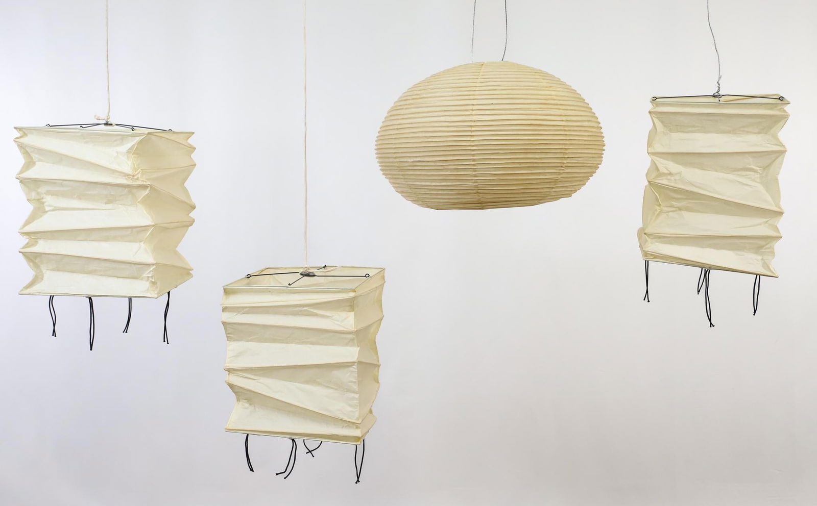 Isamu Noguchi for Ozeki Akari Lamp Shades: Japanese hanging lamp shades, mulberry paper and bamboo. Rectangular shades (3) with printed sun and moon, Japan, and artist's name, and a spherical shade with printed sun and moon. All show a few min