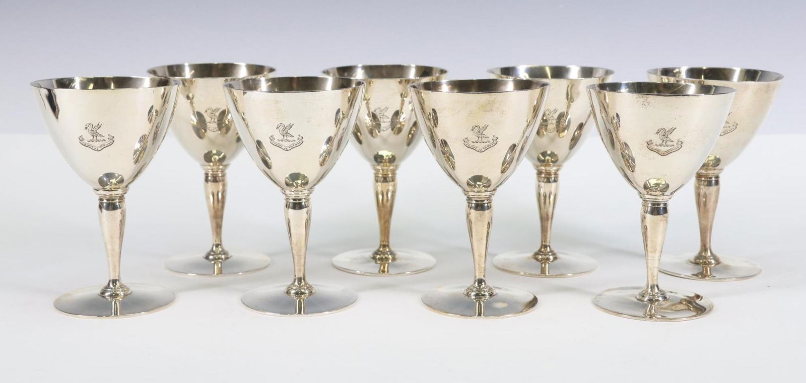 Tiffany "Faneuil" Sterling Silver Wine Goblets: American sterling silver after dinner wine goblets, a set of (8), 1915 date markings, with engraved crest. (3) pieces shows dings to the foot; other surface wear including light scratches and some min