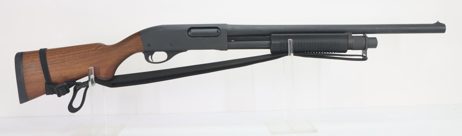 Remington 870 Police Magnum Pump Shotgun: 12Ga. 20" bbl, 3" chamber, cyl bore choke, SN B156142M. 95% gray/black parkerized finish shows average handling with small scratches and nicks with areas of tape/sticky residue, good bore, wood stock 