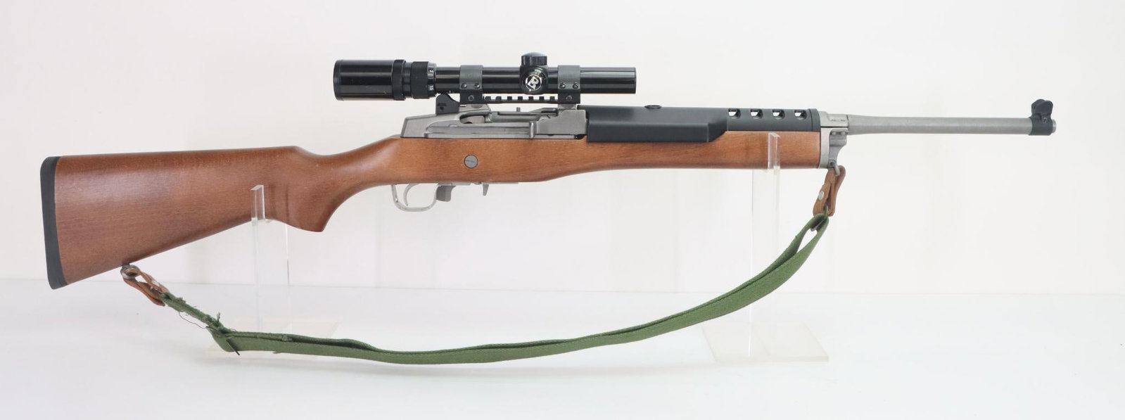 Ruger Mini 14 Semi Automatic Rifle: 5.56 Nato, 18 1/2" bbl, SN 584-53699. Matte stainless finish, good bore, blued guarded front and rear sights, plastic ventilated handguard, Bushnell sportview 1.5-4.5x rifle scope mounted with Weaver 