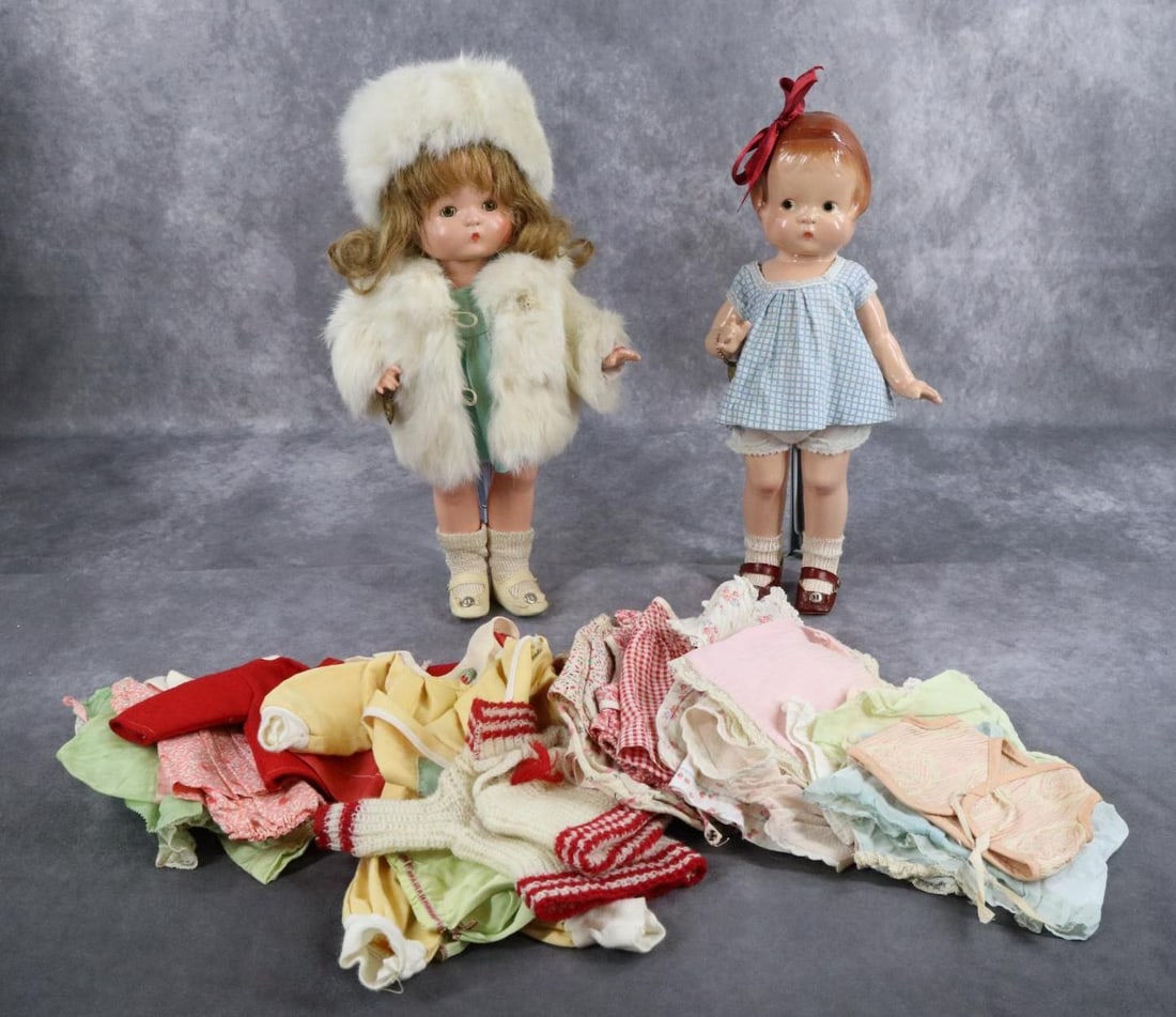 COMPOSITION - EFFANBEE.: Pair of 14" "Patsy Family" dolls, some extra clothing. Both "Patsy" dolls are wearing their brass heart bracelets. Doll 1) has molded/painted red hair brown side glance eyes. She is dressed in tagged