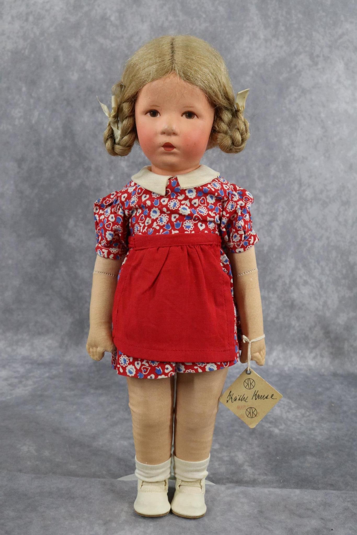 KATHE KRUSE.: 14" KATHE KRUSE doll VII 1926 - 1952 with turning head. Honey blonde human hair wig with braided loops. Original hang tag. Jointed body with slim swivel hips. Clothing appears all original inc. ivory 