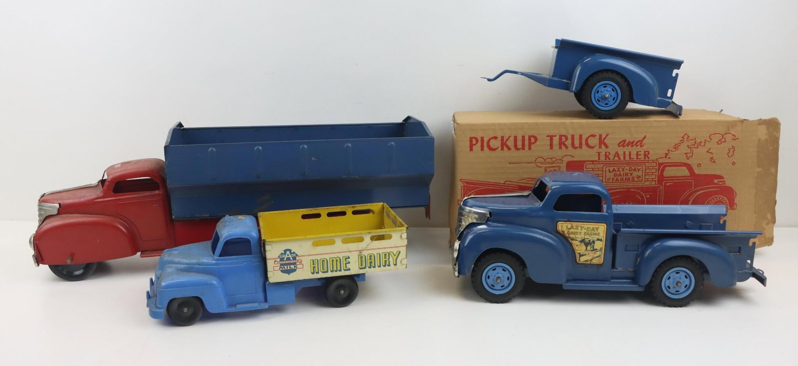 Louis Marx Trucks: Louis Marx pressed steel dump truck, red and blue, in working order, 21" length, minor wear. Marx Home Dairy delivery truck, tin lith and plastic, 11.75" length. Marx pressed steel Lazy Dairy pick-up 