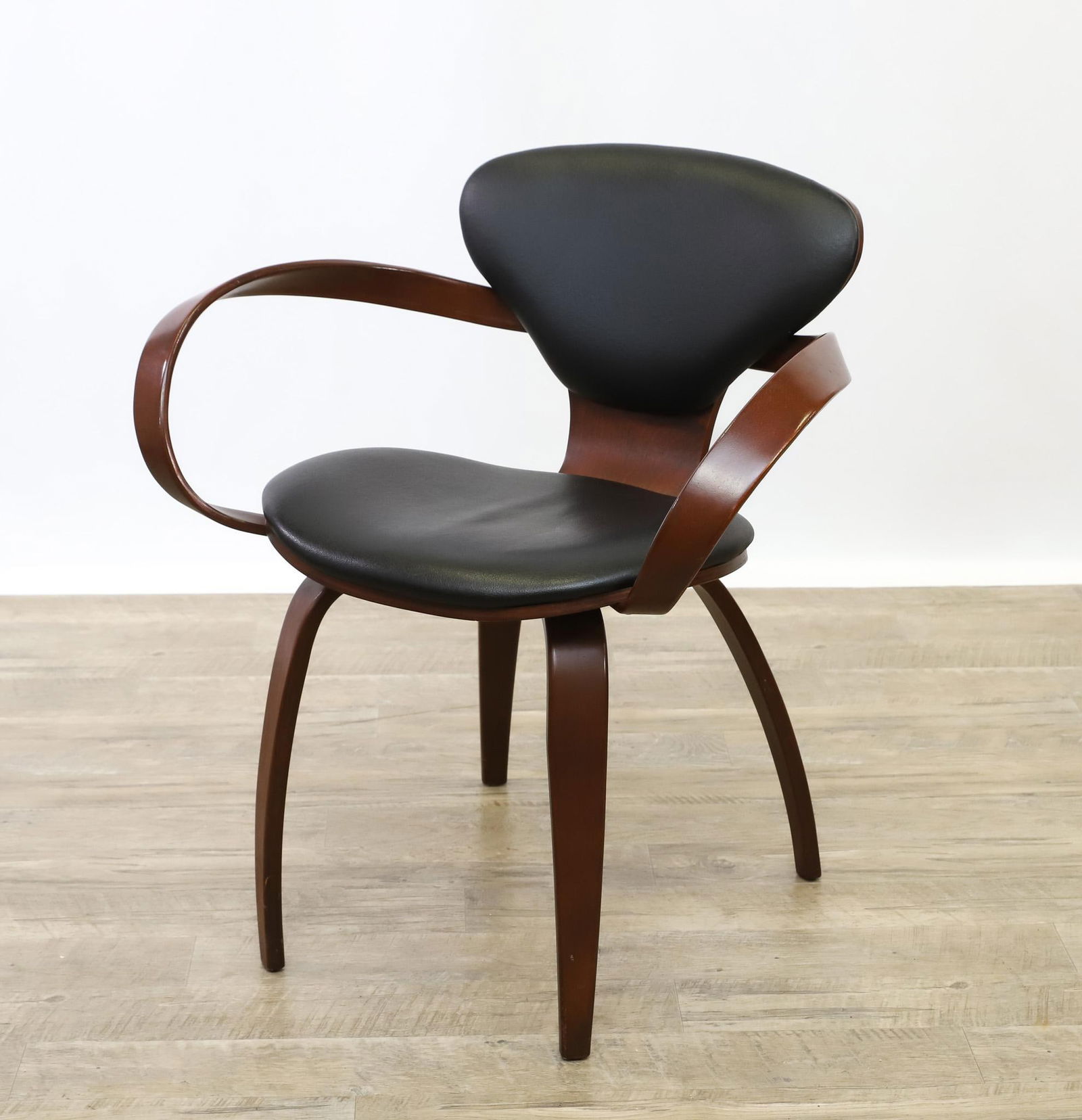 Levenger "Goldman" Chair: Molded plywood with a walnut veneer and vinyl upholstery, a re-issue of the original "Pretzel" chair designed by Norman Cherner for Paul Goldman of Plycraft. 30.5"h x 28"w x 23.5"d, seat height 19"