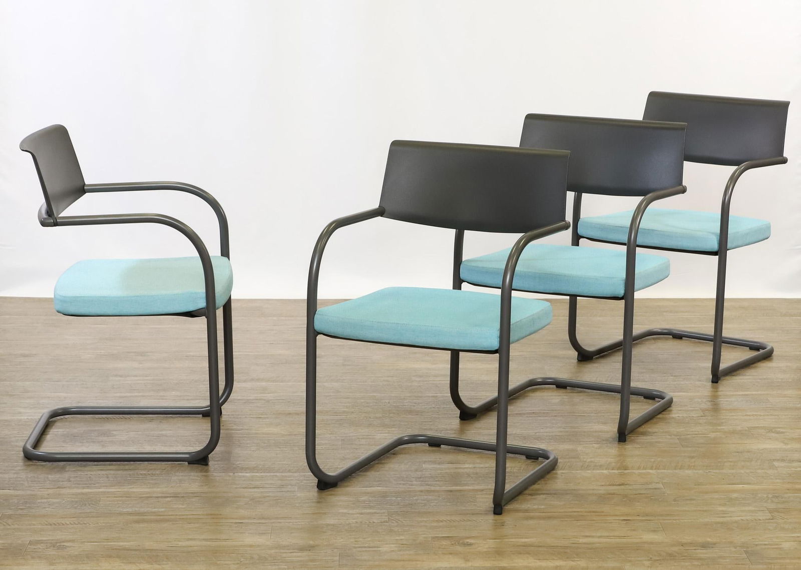 Jeffrey Bernett and Nicholas Dodziuk for Knoll "Moment" Guest Chairs: Contemporary cantilevered stacking armchairs by Knoll, a set of (4), with metallic gray tubular steel frames, molded plastic and nylon backs, and teal upholstered foam seats. 32"h x 21"w x 21"d, seat
