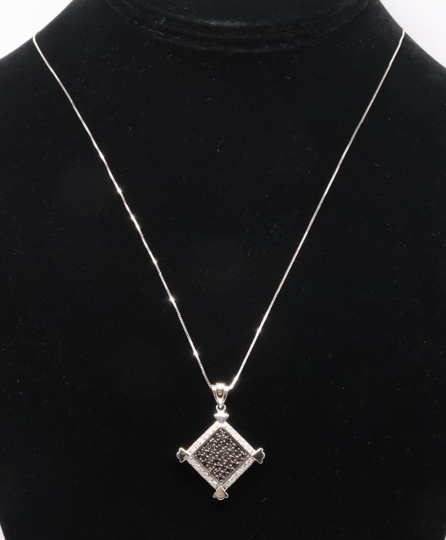 14k WG Black Diamond Pendant: 14k white pendant set with (40) round cut black diamonds framed by (24) round cut diamonds. Approx. 1.0 carat total weight. 18" chain and